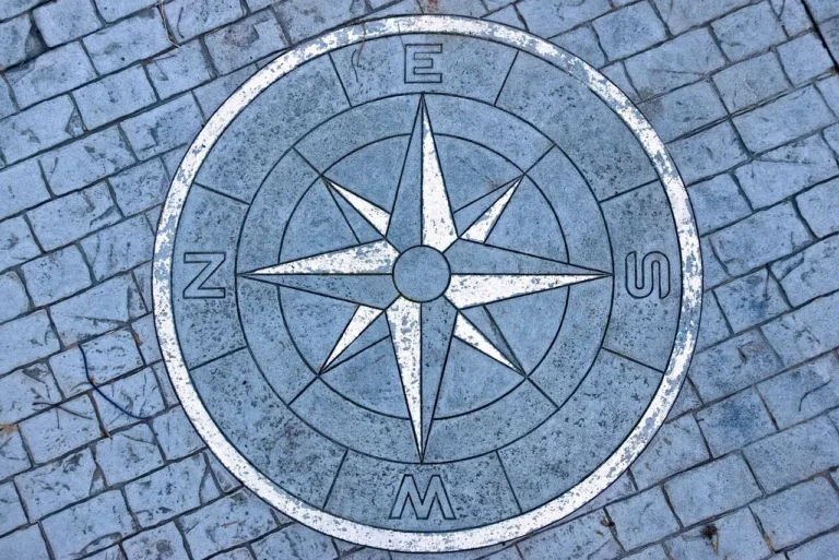 Photo of a compass set among flagstones.